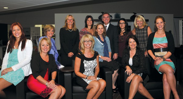 Jean-François Tremblay, directeur général de BMW Sainte-Julie, entouré du comité organisateur du party de filles dans un garage